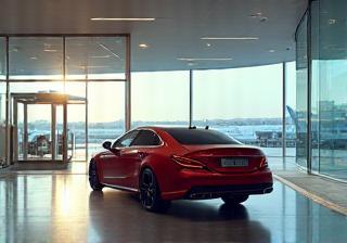 Luxury car arriving at a modern airport terminal building