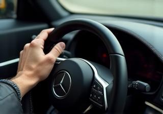 Hands on a luxury car steering wheel during a self-drive experience